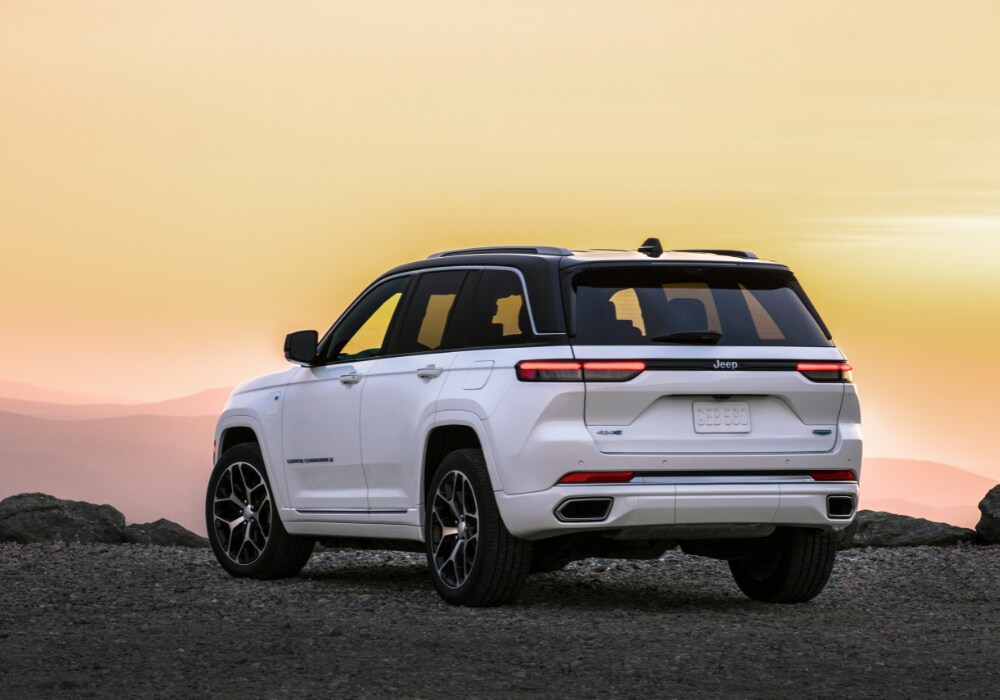 Jeep Grand Cherokee parked facing away from the camera overlooking a foggy mountain range