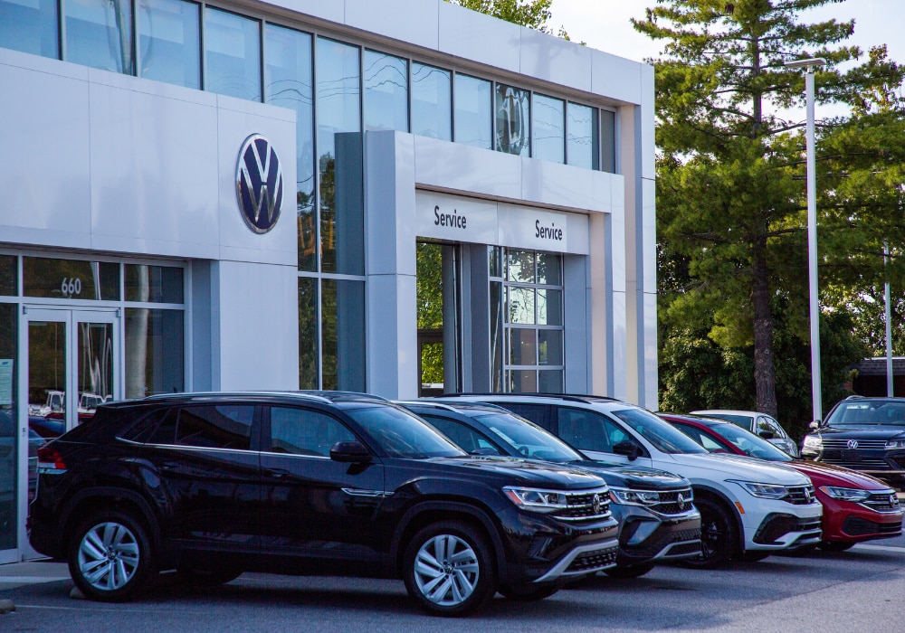 Lineup of Volkswagen cars parked outside the Flow Volkswagen of Burlington dealership