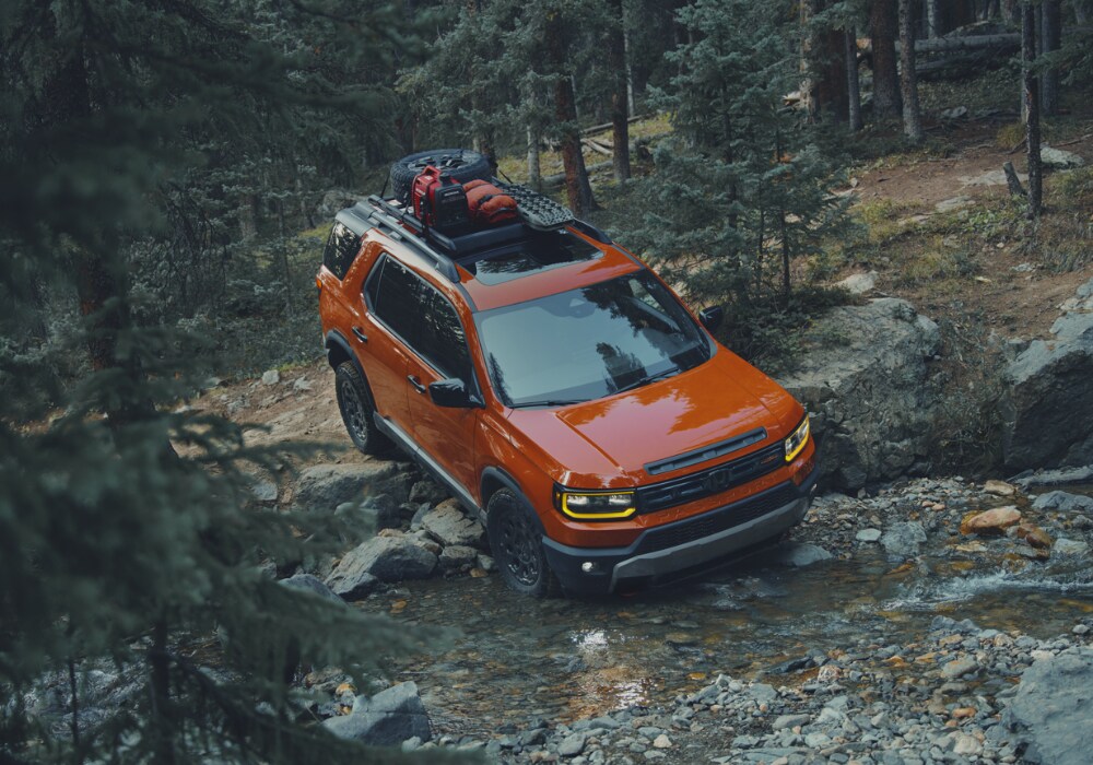 honda-passport-specs.png 2026 Honda Passport driving off road in a wooded area