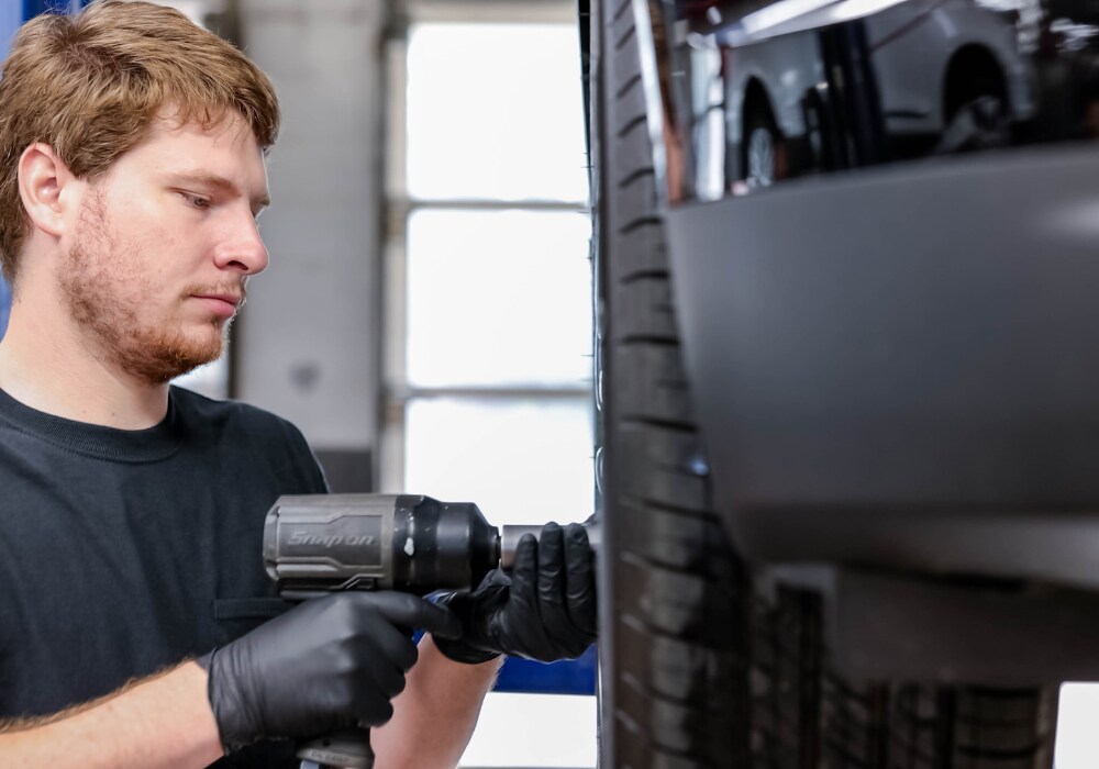 Service technician working on the tire of a car