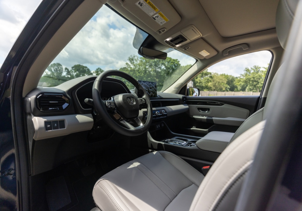 2025 Honda Pilot interior, including the entire front dash, steering wheel and infotainment system