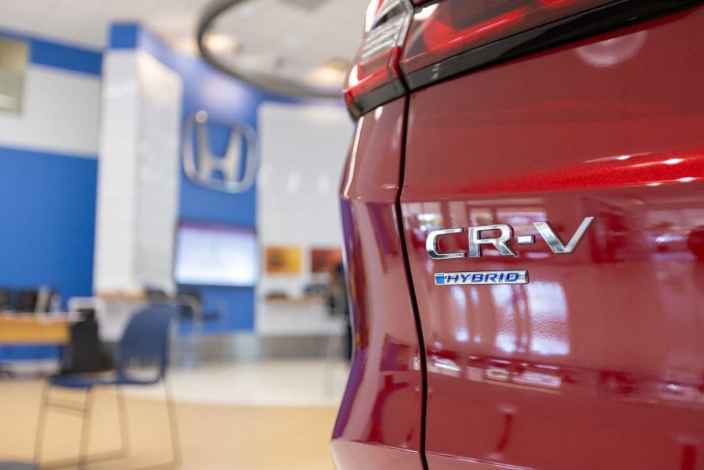honda-cr-v-hybrid-winston-salem.jpg Close up view of Honda CR-V Hybrid emblem displayed on back of vehicle in Honda dealership showroom
