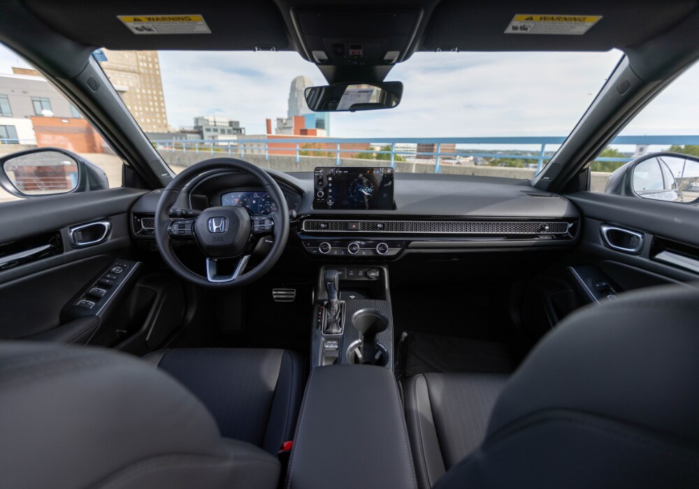 honda-civic-sport-hybrid-dashboard.png Photo shows the dashboard of a Honda Civic Hybrid Sport. There is a city skyline visible out of the front window