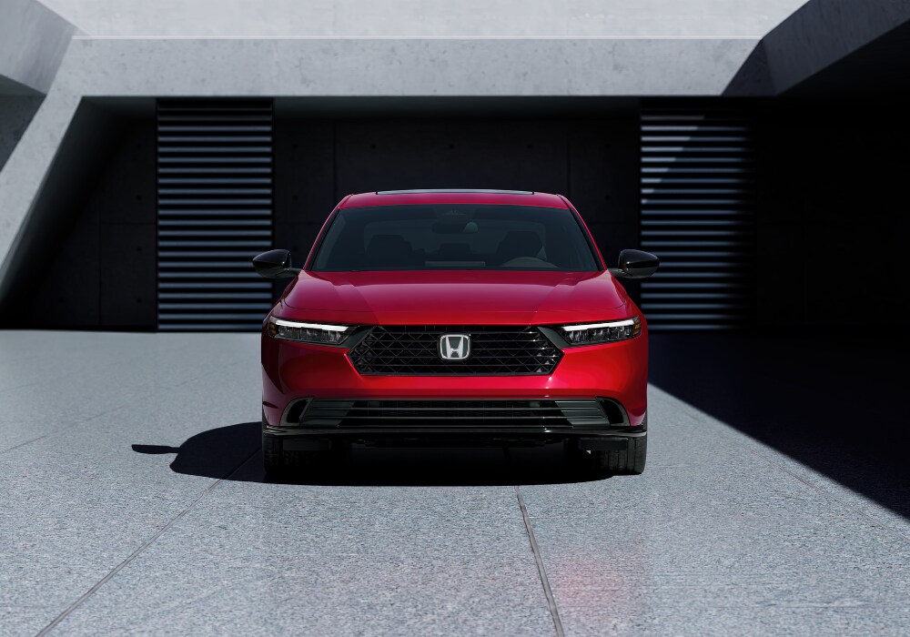 New Honda Accord Hybrid parked facing the camera with a large building in the background
