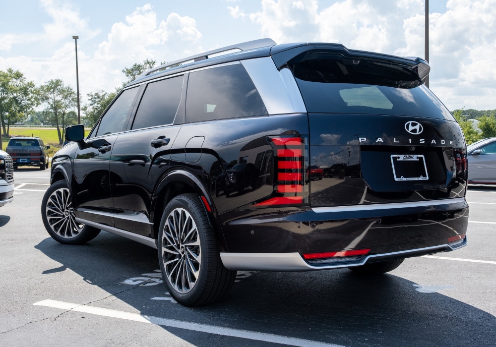 2025-hyundai-palisade-for-sale.png Rear exterior view of a 2025 Hyundai Palisade for sale. The SUV is the color black