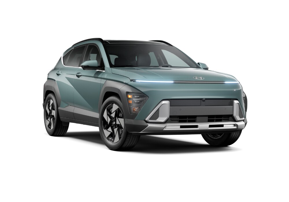 hyundai-kona-compact-suv.png Green Hyundai Kona with its headlights on in front of a white background