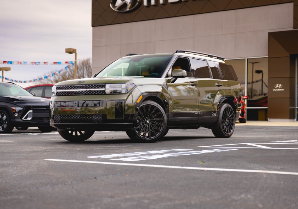 Green 2026 Hyundai Santa Fe SUV parked in front of a Hyundai dealership