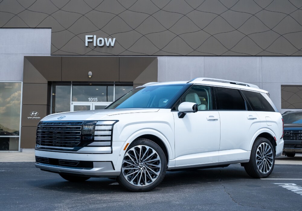 hyundai-palisade-for-sale-near-statesville.png White Hyundai Palisade for sale parked in front of the Flow Hyundai of Palisade dealership
