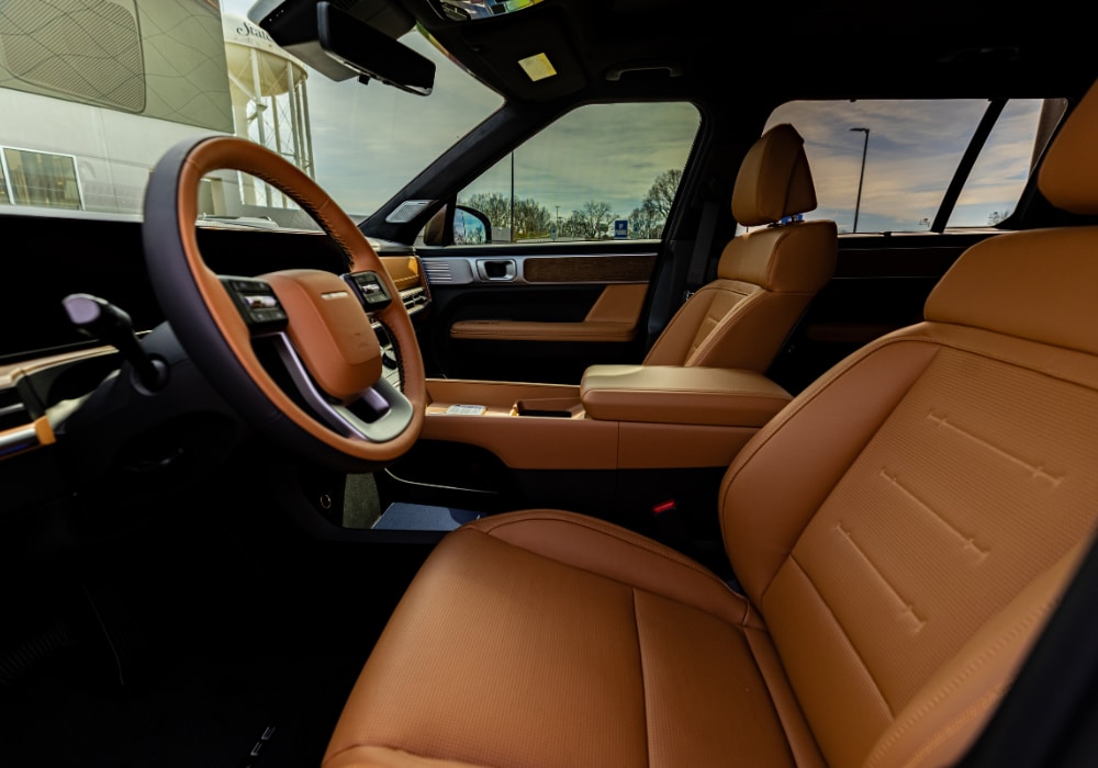 Hyundai Santa Fe Hybrid interior, featuring brown leather upholstery, steering wheel, and an infotainment system