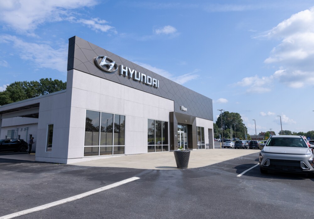 Flow Hyundai of Statesville dealership storefront. There is a Hyundai for sale parked in front of the building
