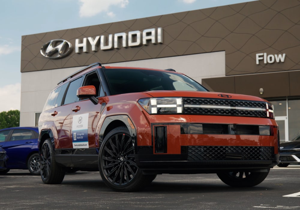 Orange Hyundai Santa Fe in front of a Flow Hyundai dealership
