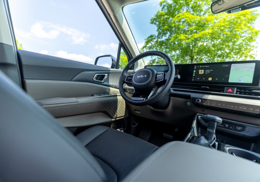 2025 Kia Carnival Interior, showing the driver's seat, steering wheel, and infotainment system