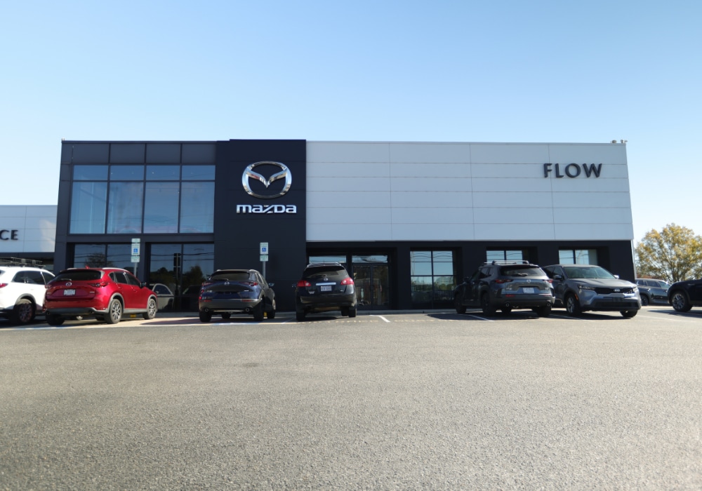 The Flow Mazda of Fayetteville dealership with several cars parked outside