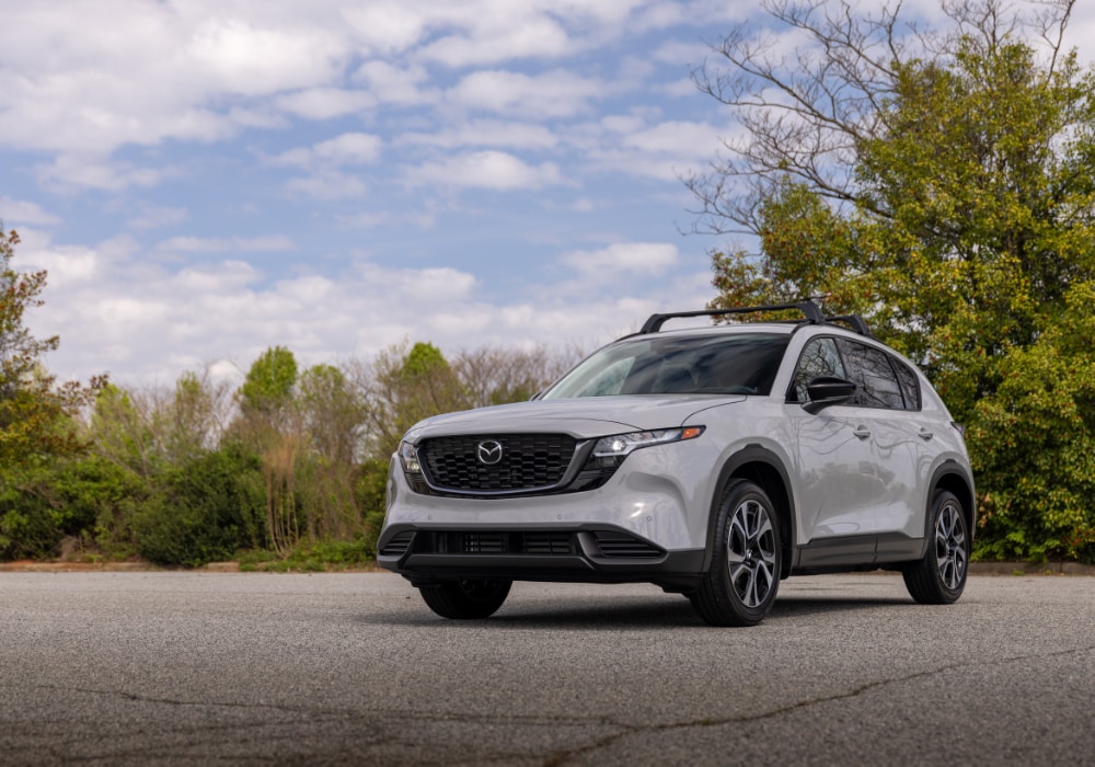 Gray 2026 Mazda CX-5 parked in a paved lot with trees in the background