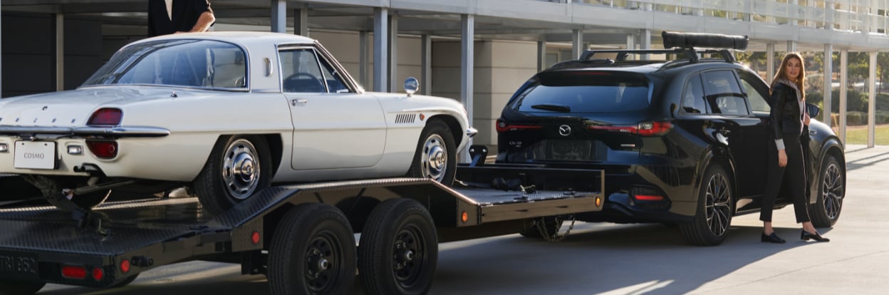 mazda-cx70-vs-cx90.png Black Mazda CX-70 hauling a small white car
