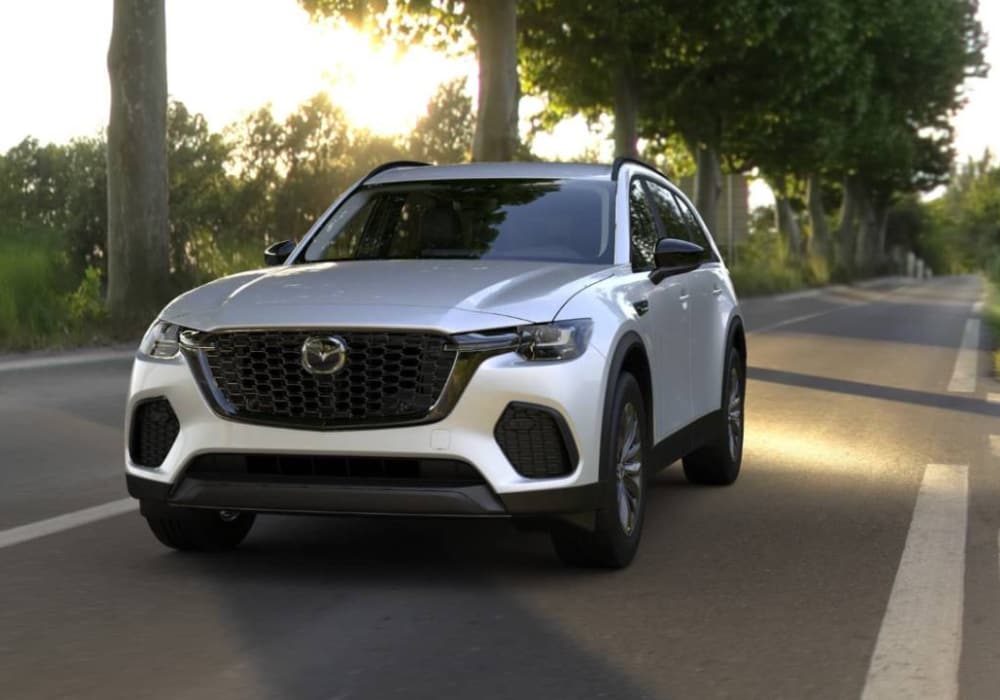 Front view of a 2026 Mazda CX-70 Plug-In Hybrid driving down a road