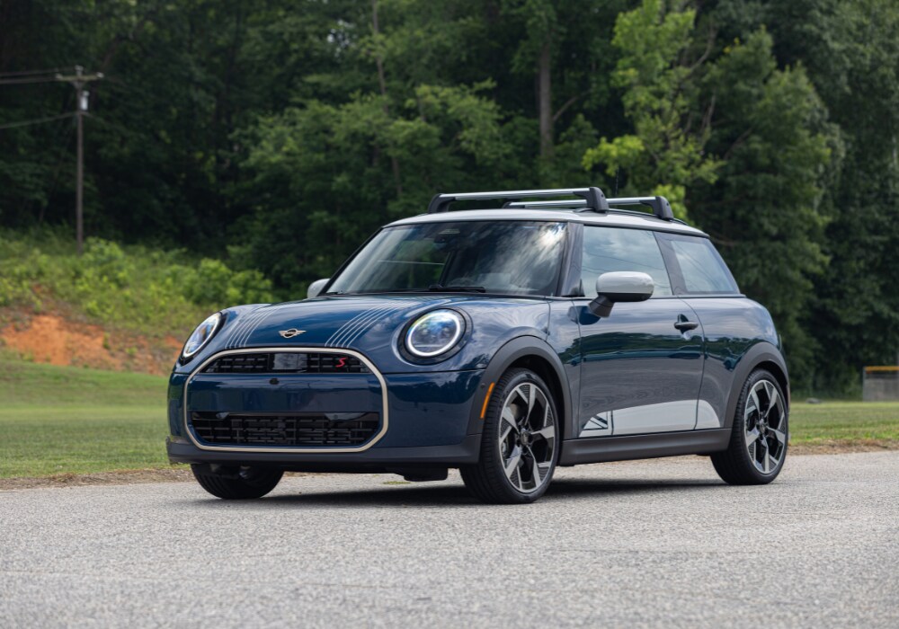 Front view of a 2026 Mini Cooper 2 door car. The vehicle is dark blue with light gray details