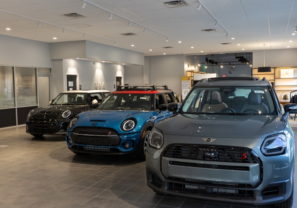 Several MINI cars for sale parked inside a MINI Cooper dealership located in Raleigh, NC