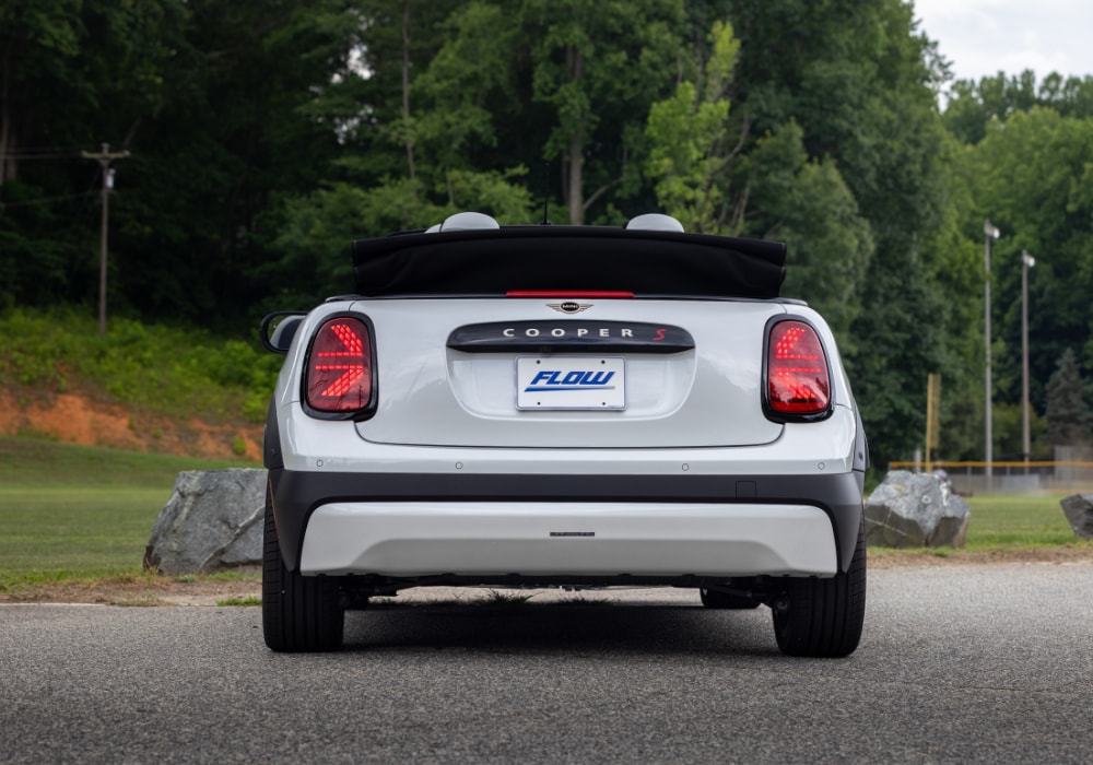 Rear exterior of the 2026 Mini Cooper Convertible. The top is down and there is a Flow Automotive vanity license plate on the back of the car