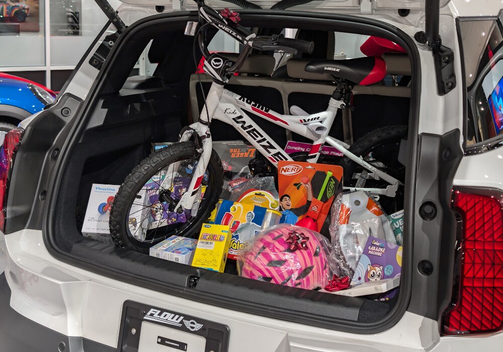 the trunk of a new mini filled with new kids toys. The mini is parked in the showroom at Flow MINI of Raleigh
