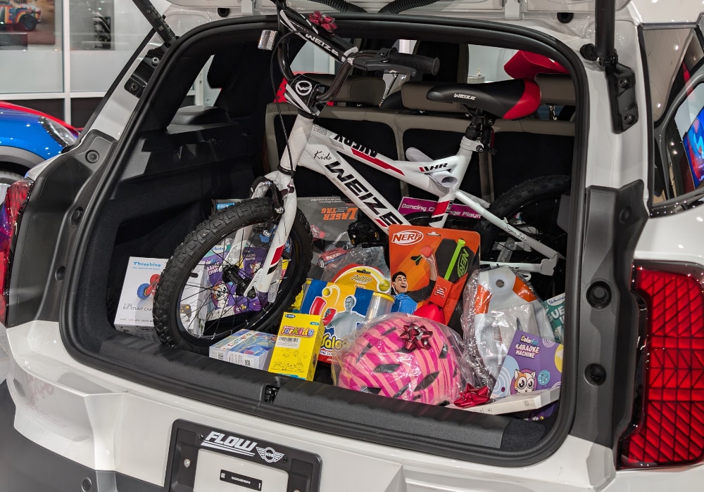 the trunk of a new mini filled with new kids toys. The mini is parked in the showroom at Flow MINI of Raleigh