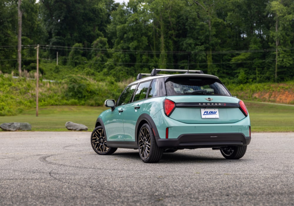 Rear view of a new 4 door Mini Cooper for sale. The car is light teal with white details