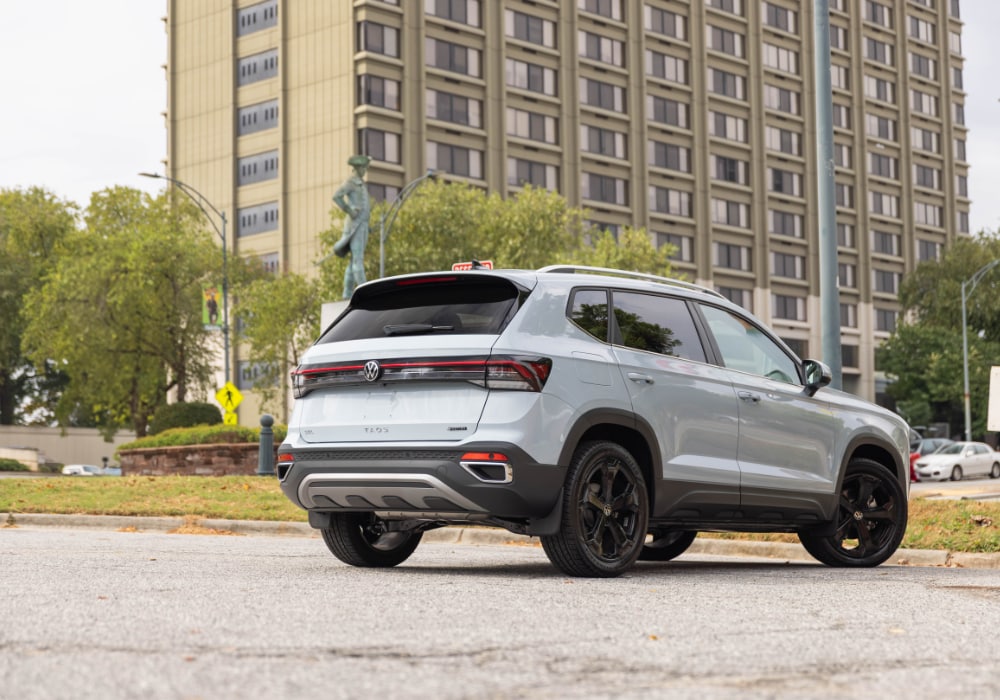 A new Volkswagen Taos parked next to a building