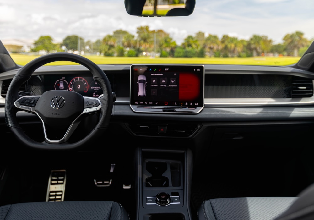 Volkswagen Tiguan interior. The photo shows the entire front dash including the steering wheel and infotainment system. 