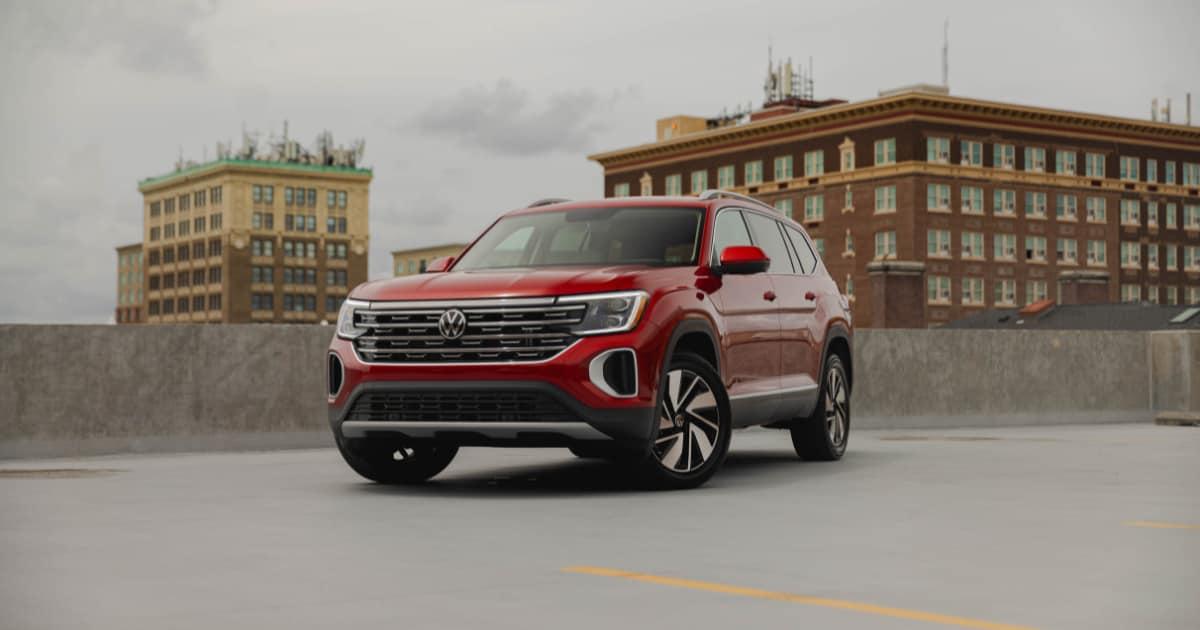 Red 2025 Volkswagen Atlas parked on top of a parking deck with buildings in the background