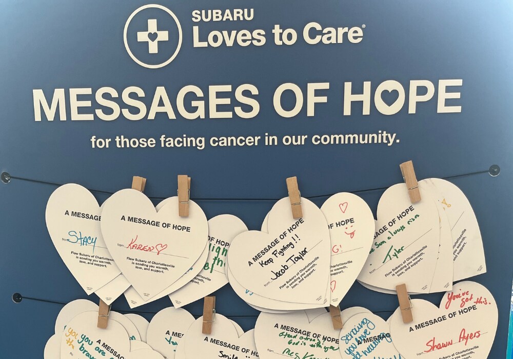 A board that says Messages of Hope with several paper cutouts in the shape of hearts. The paper cut outs have writing on them