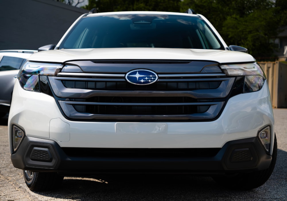 Close up photo of the front grille of a new Subaru Forester SUV parked in a dealership lot