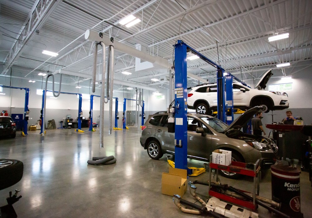 Cars being worked on inside the service center at Flow Subaru