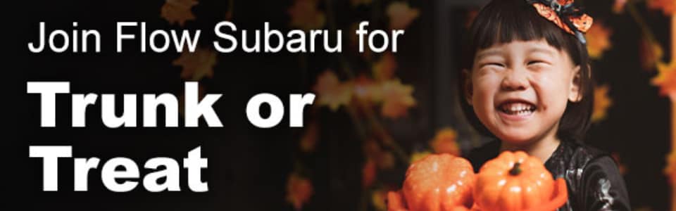A child smiling and holding two small pumpkins next to text that reads Join Flow Subaru for Trunk or Treat