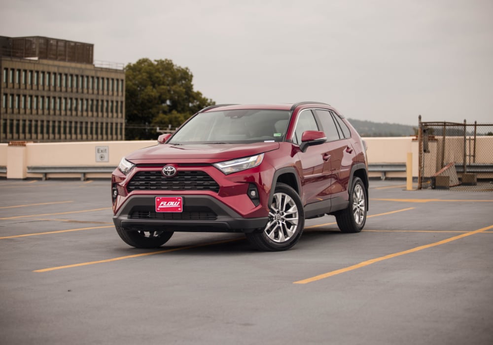 Red 2025 Toyota RAV4 SUV parked in an empty lot