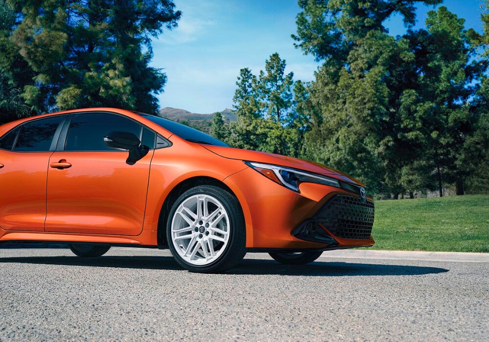 toyota-sedans-for-sale.png Orange Toyota Corolla parked on a gravel road