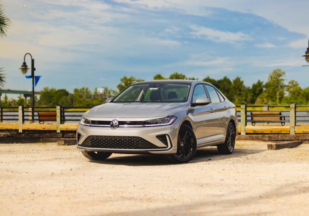 2025 Volkswagen Jetta parked in a lot with trees and water in the background