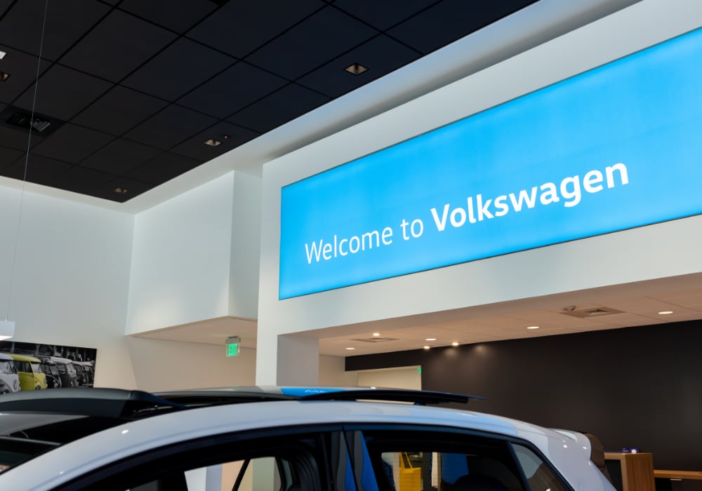 Light blue sign with white text that reads Welcome to Volkswagen. The sign is inside a Volkswagen dealership located in Asheville, NC