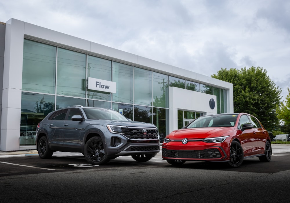 Two new Volkswagen cars for sale parked outside of the Flow Volkswagen of Asheville dealership