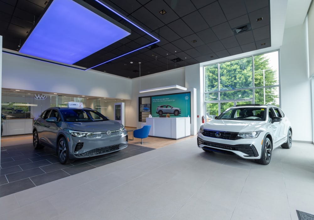 Two Volkswagen SUVs parked inside the showroom at Flow Volkswagen of Asheville
