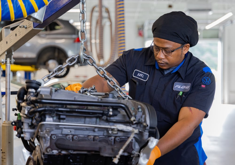 service technician removing an engine from a car