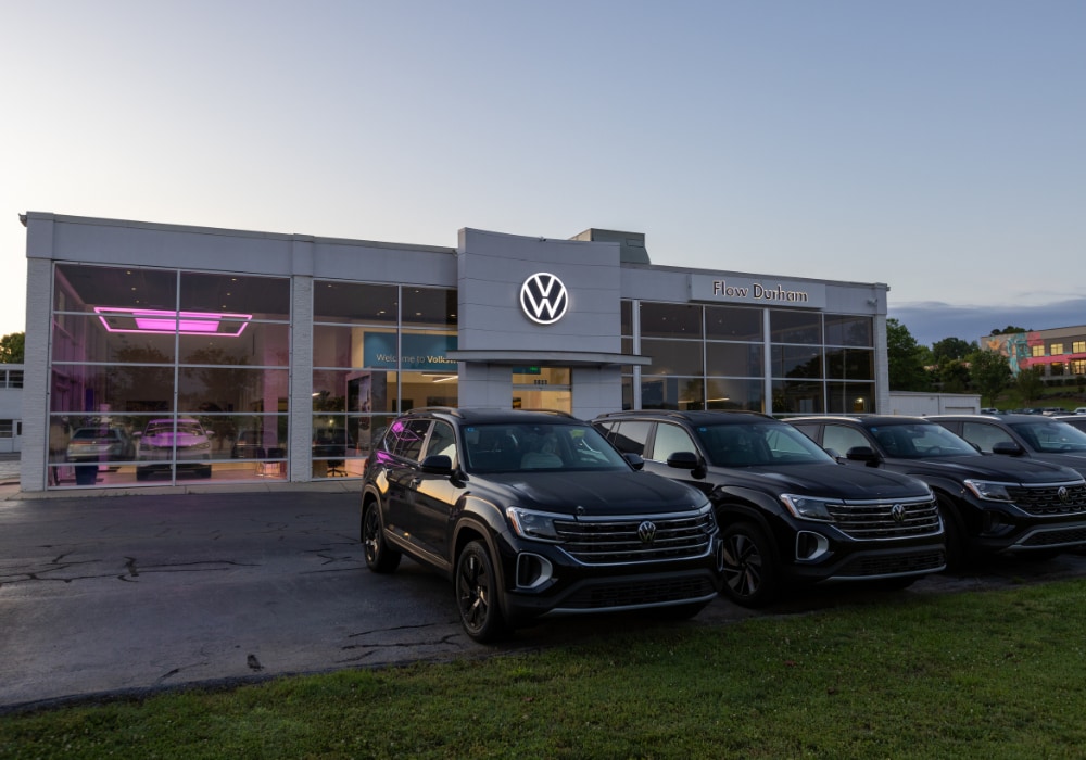 Storefront of Volkswagen of Durham with several Volkswagen vehicles parked outside the dealership
