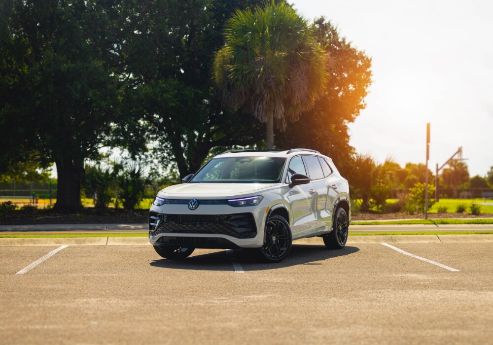 Volkswagen Tiguan parked in an empty lot with the sun shining in the background