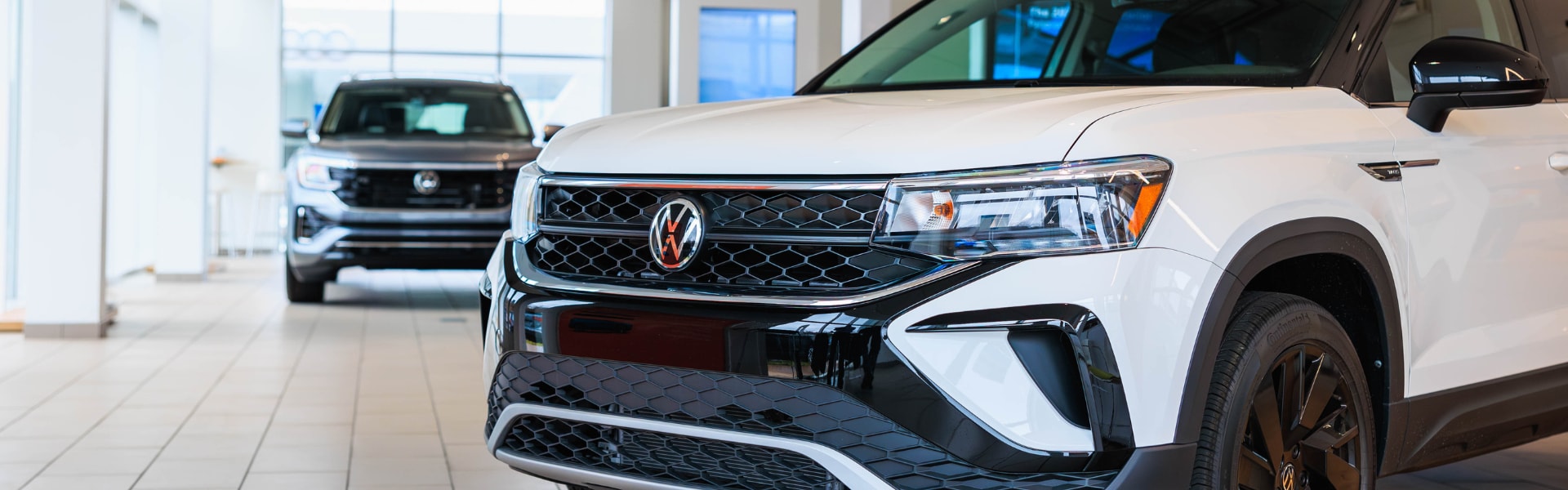 White Volkswagen SUV parked inside a dealership showroom