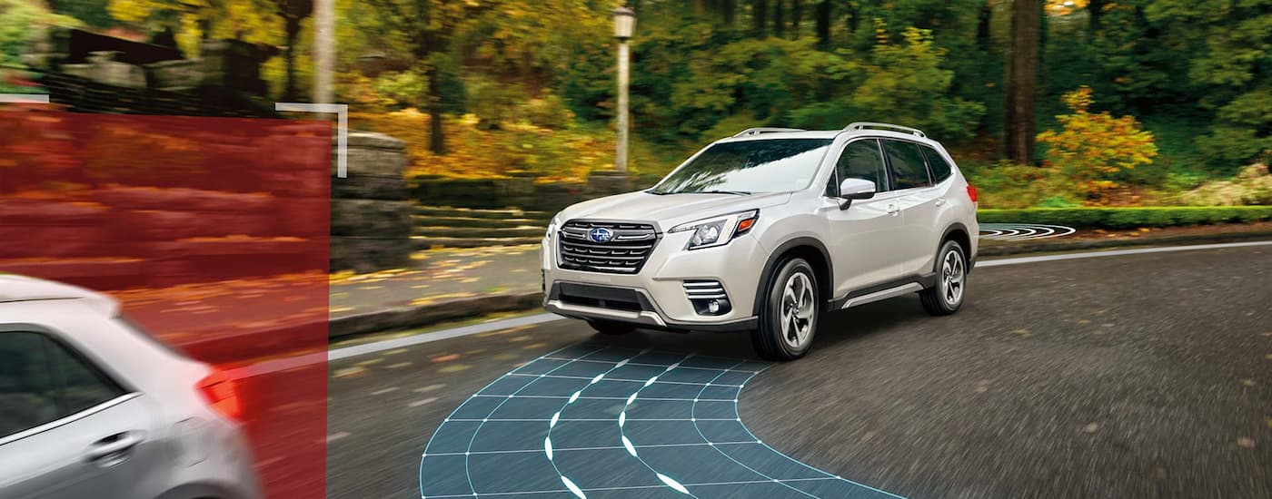 A white 2022 Subaru Forester is shown driving behind a car with simulated sensor lines.