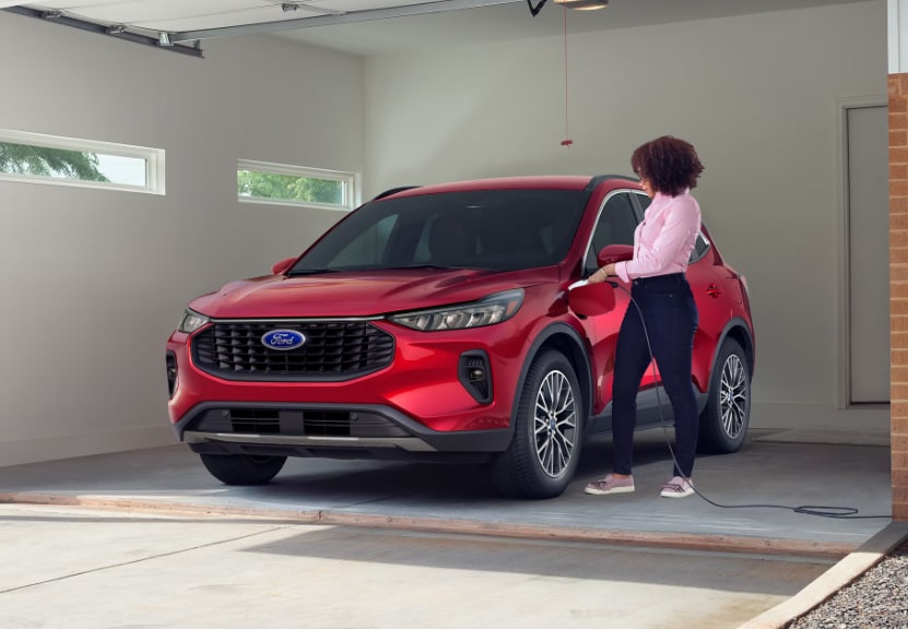 Red 2026 Ford Escape PHEV plugged into charger