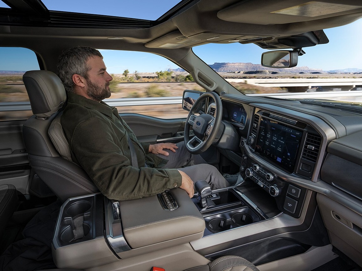 A profile of a man operating BlueCruise moving in desert landscape