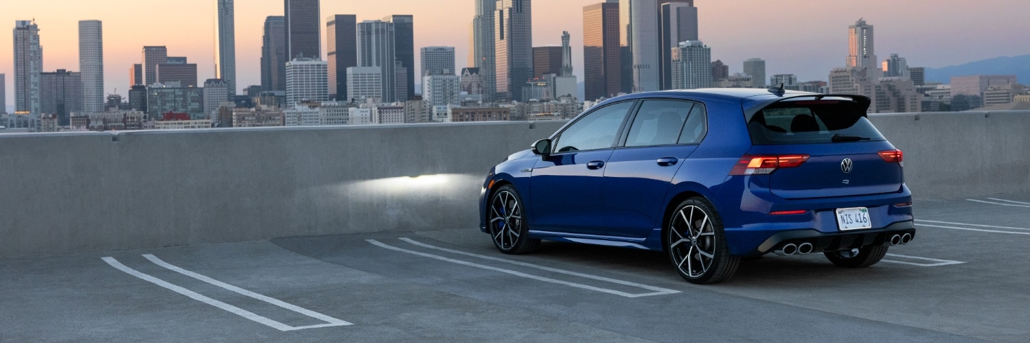 Volkswagen Golf R parked on an upper deck of overlooking a city skyline
