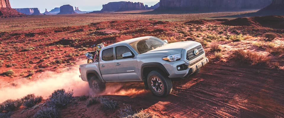 A silver 2019 Toyota Tacoma driving through the desert