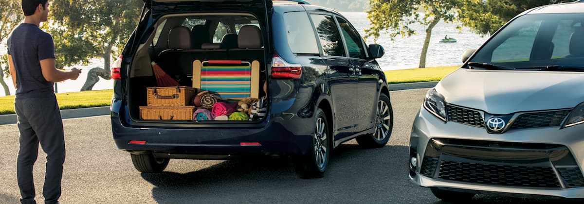 2019 Toyota Sienna A man filling up a black 2019 Toyota Sienna with a grey 2019 Toyota Sienna parked next to it