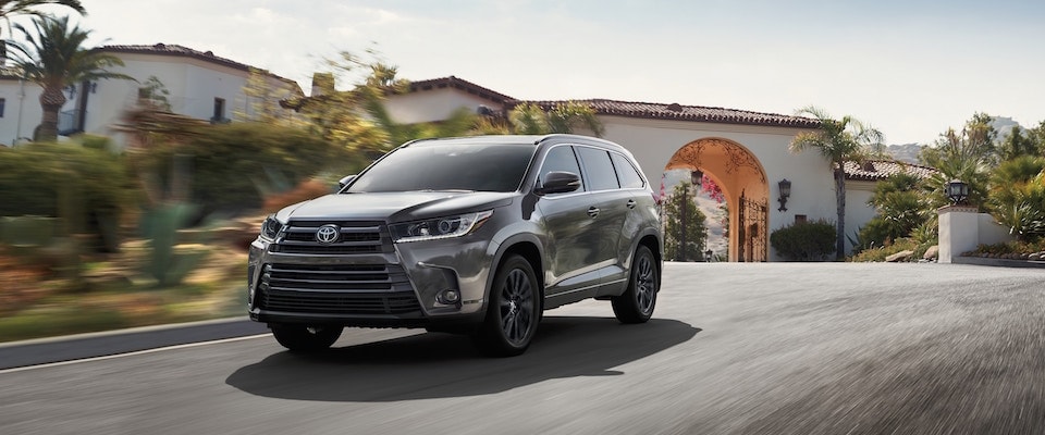A black 2019 Toyota Highlander driving down the street